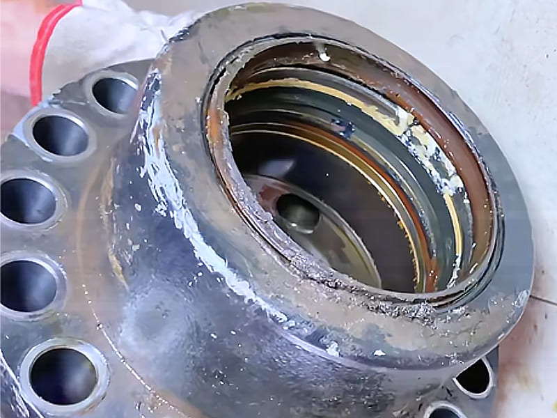 Faulty hydraulic cylinder flange head, internal sealing groove damaged by welding residue slag, causing oil leakage failure