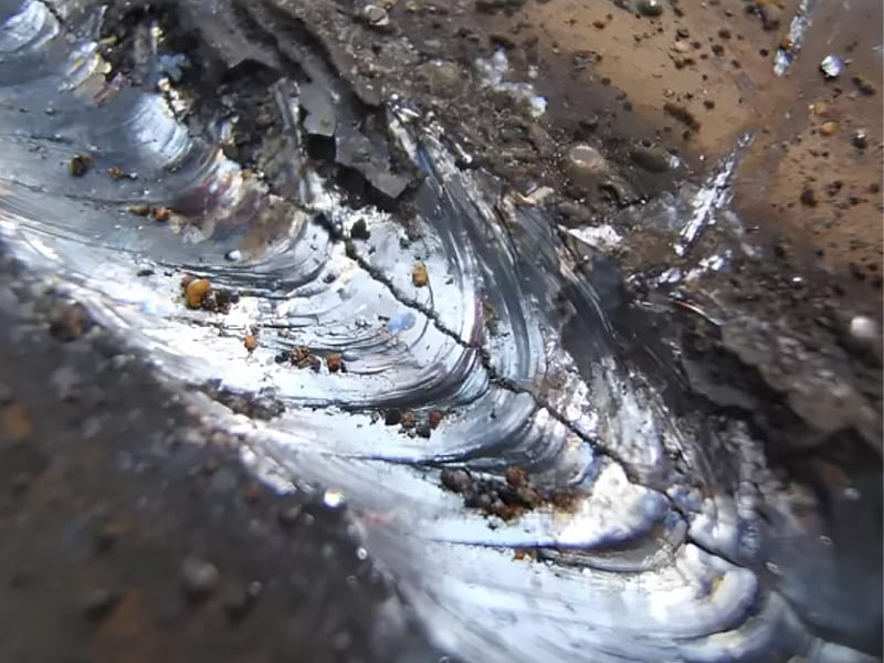 Weld crack defect on hydraulic cylinder welding seam, metal welding failure close-up