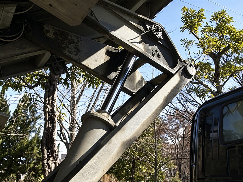 Close‑up view of hydraulic cylinder on aerial lift truck boom assembly outdoor