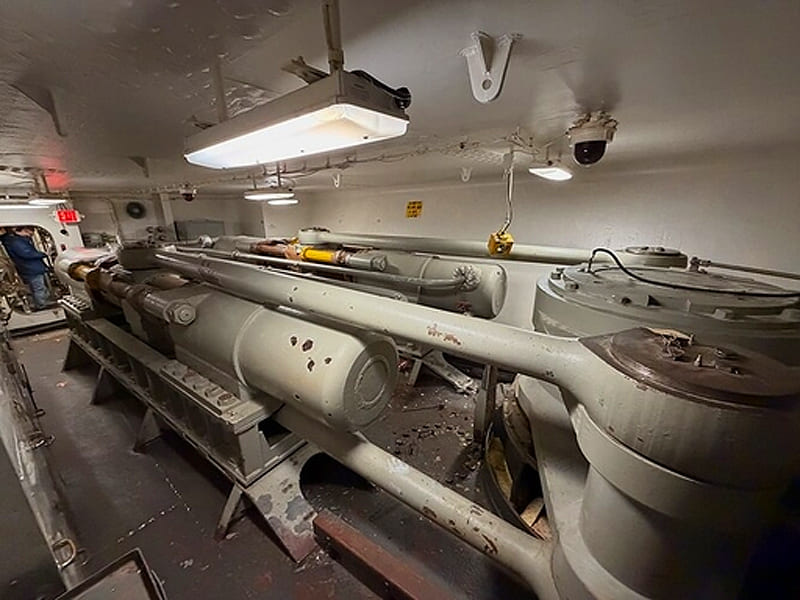 Massive heavy‑duty marine hydraulic cylinders assembled inside ship interior cabin space