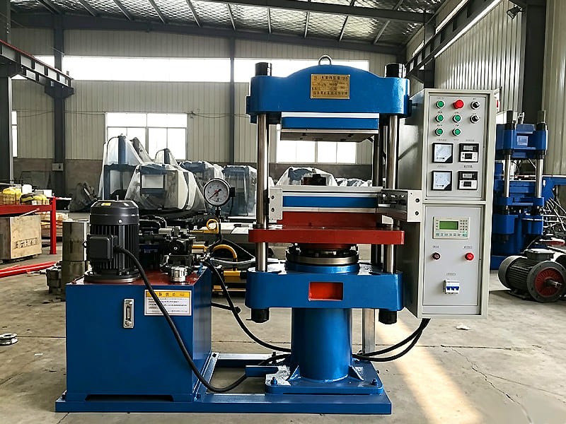 Blue four‑post hydraulic hot pressing vulcanizer in factory workshop