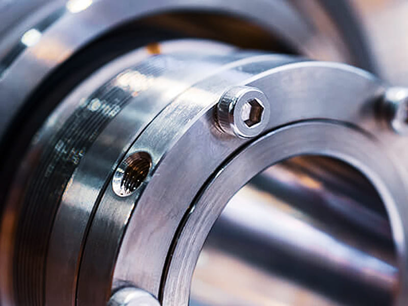 Close‑up of metal hydraulic cylinder end cap with hex socket head cap screws