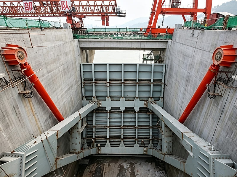 Large hydraulic cylinders operating dam sluice gate at hydropower construction site