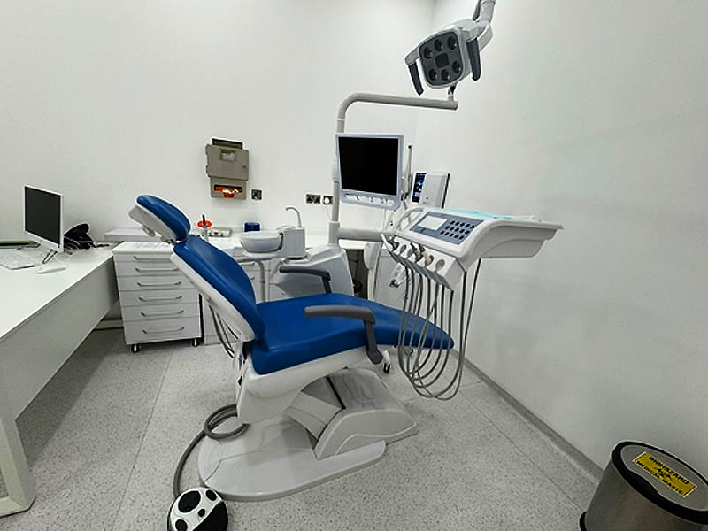 Complete dental chair equipment with operating light and monitor inside bright dental clinic