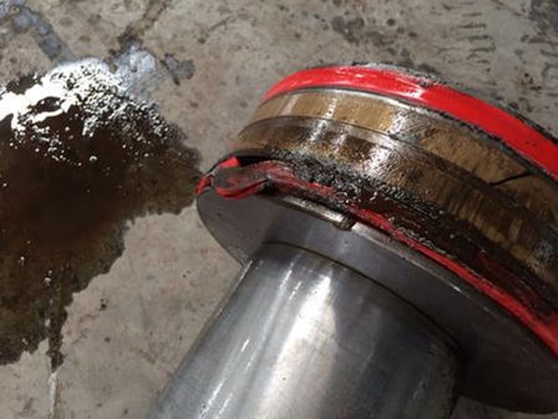 Failed red composite seal ring of hydraulic cylinder with oil leakage