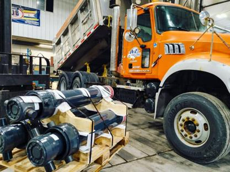 Heavy‑duty hydraulic cylinders fixed on wooden pallets ready for truck delivery