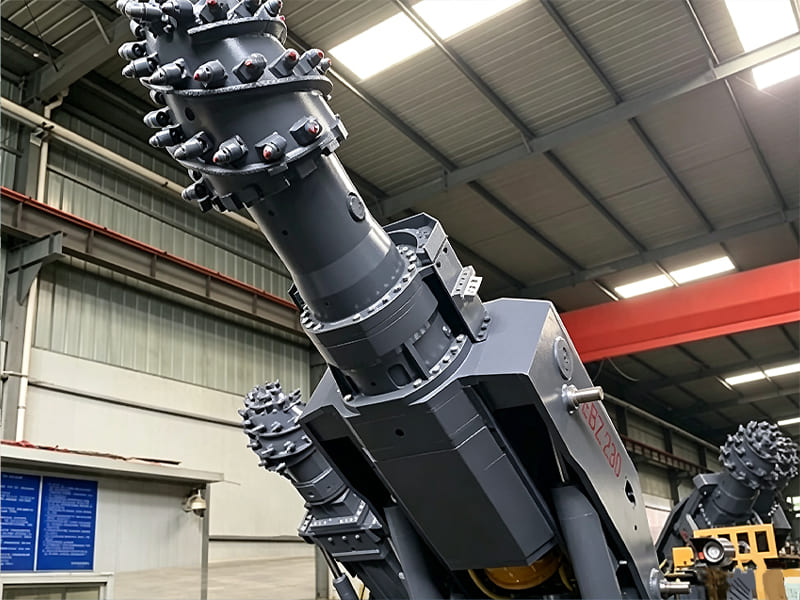 Heavy‑duty roadheader cutting head with rock cutting picks inside workshop
