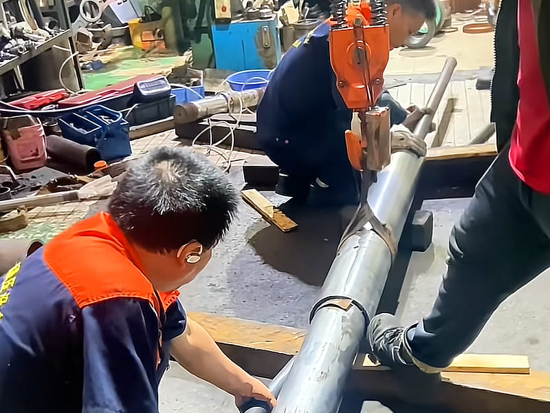 Technicians install and assemble large bore hydraulic cylinder on workshop site