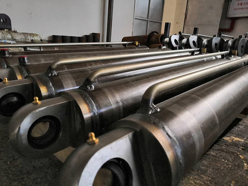 Batch of heavy‑duty hydraulic cylinders with built‑in pipeline in workshop
