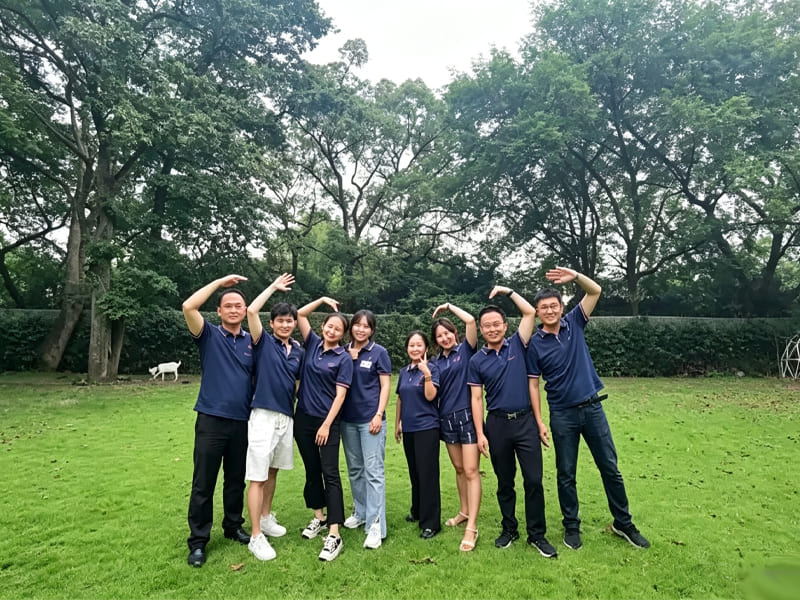 Corporate team building photo on green lawn with uniform polo shirts