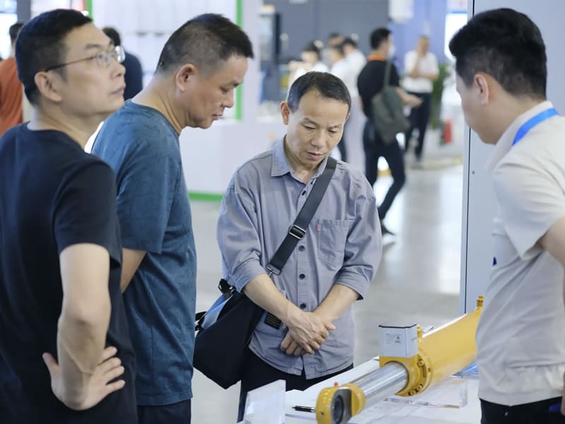 Industry customers discuss technical parameters of hydraulic cylinder products at exhibition booth