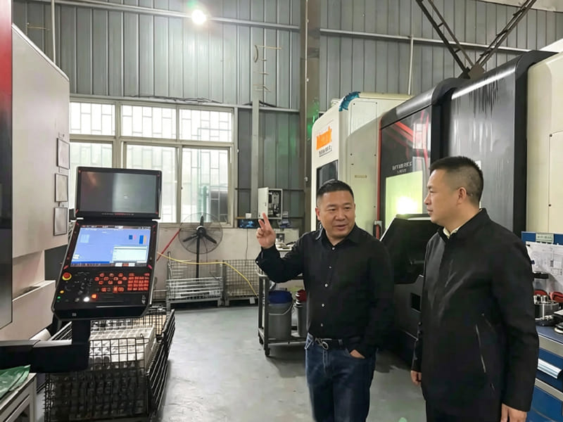 Factory manager introducing CNC machining equipment to visiting customers