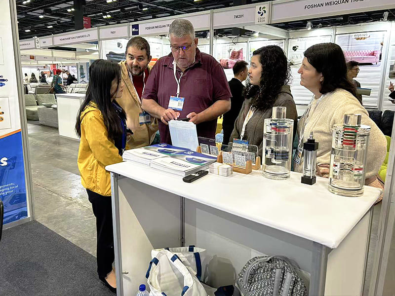 Foreign buyers checking hydraulic cylinder catalog at exhibition booth
