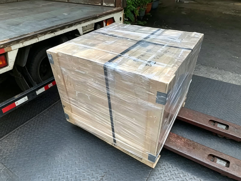 Wooden package of hydraulic cylinder wrapped stretch film on forklift for truck loading