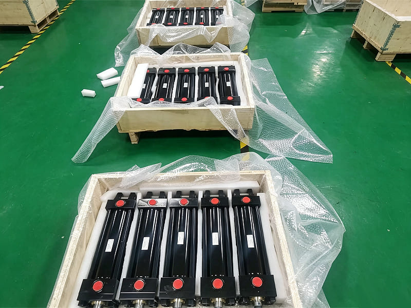 Small black hydraulic cylinders fixed by foam padding inside export wooden box