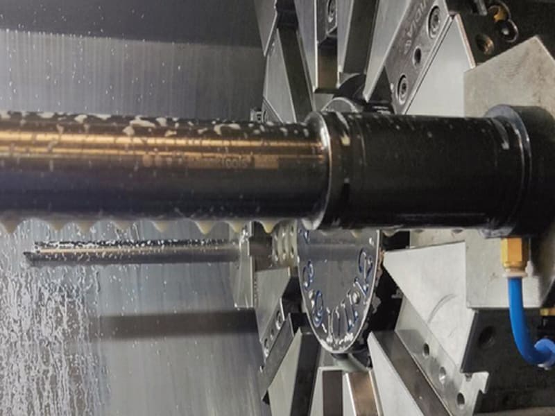 CNC lathe processing high‑precision hydraulic cylinder piston rod with cutting fluid