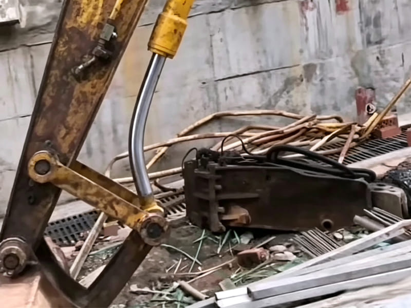 Damaged bent piston rod of excavator bucket hydraulic cylinder on construction site