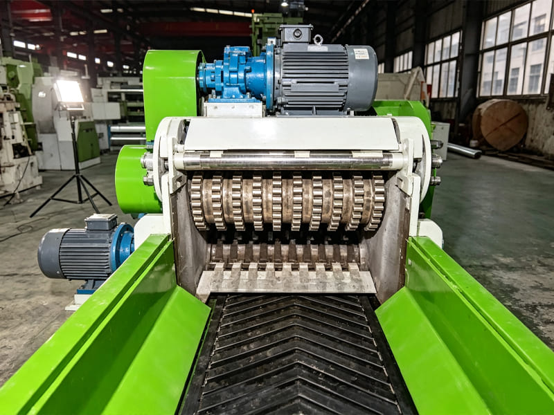 Green‑white industrial wood crusher machine, conveyor feeding port inside workshop plant