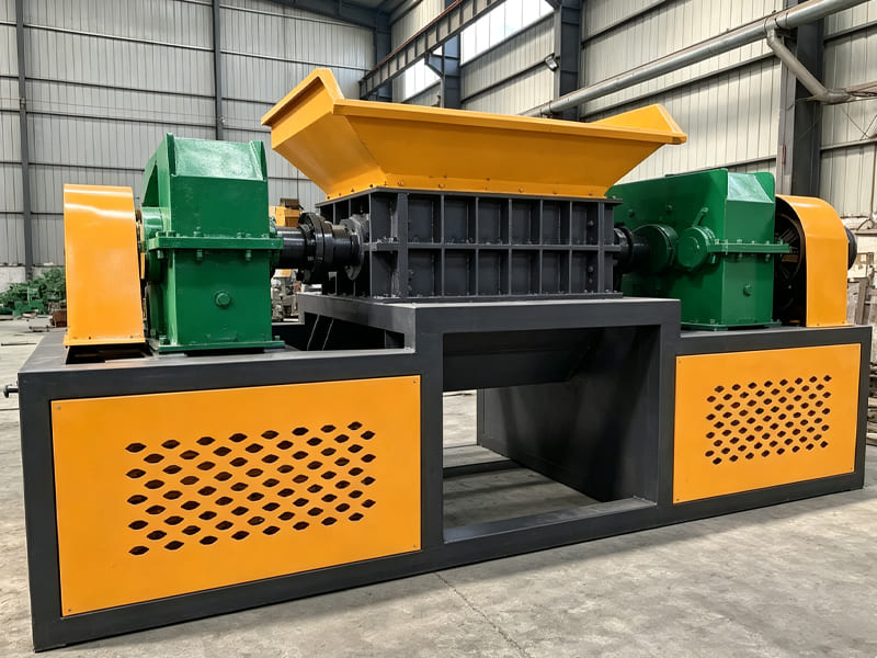 Yellow‑green heavy‑duty double‑shaft shredder for wood and solid waste processing inside factory