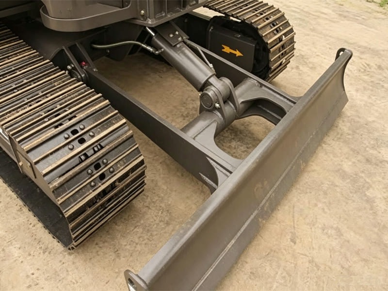 Close‑up view of excavator track frame and dozer blade hydraulic cylinder