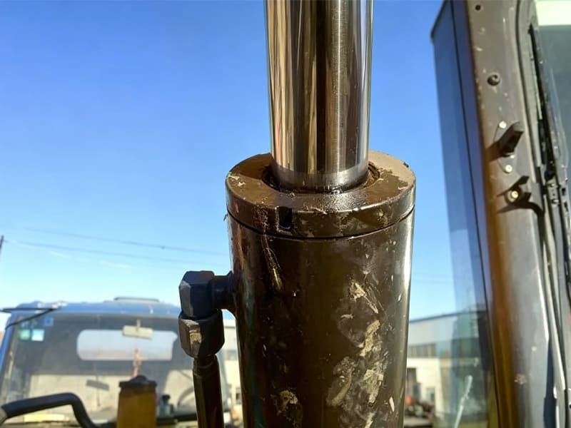 Macro close‑up of excavator cylinder piston rod and sealing gland assembly