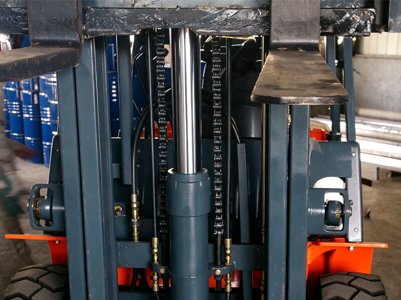 Close‑up view of forklift mast, central hydraulic cylinder, lifting chains and hydraulic hoses inside forklift