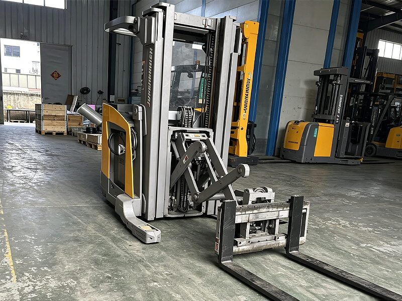 Warehouse reach truck, mast structure and scissor‑type fork attachment inside factory workshop