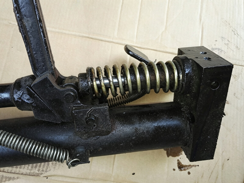 Close‑up of manual hydraulic pump internal structure, return spring and valve mechanism