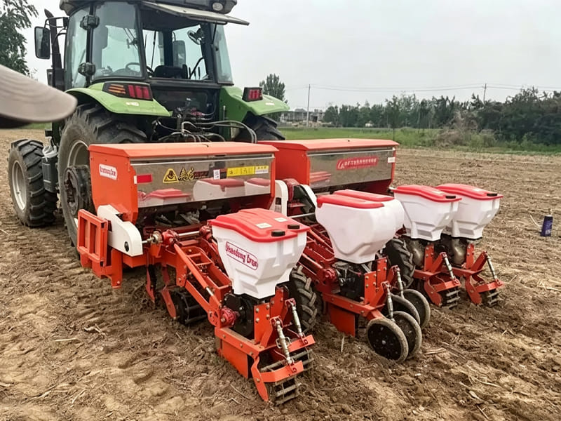 Tractor‑pulled no‑till planter working on farm field soil