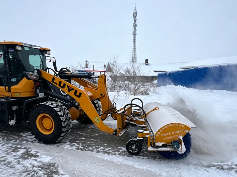 LUYU wheel loader with snow broom attachment clearing heavy snow in snowfall