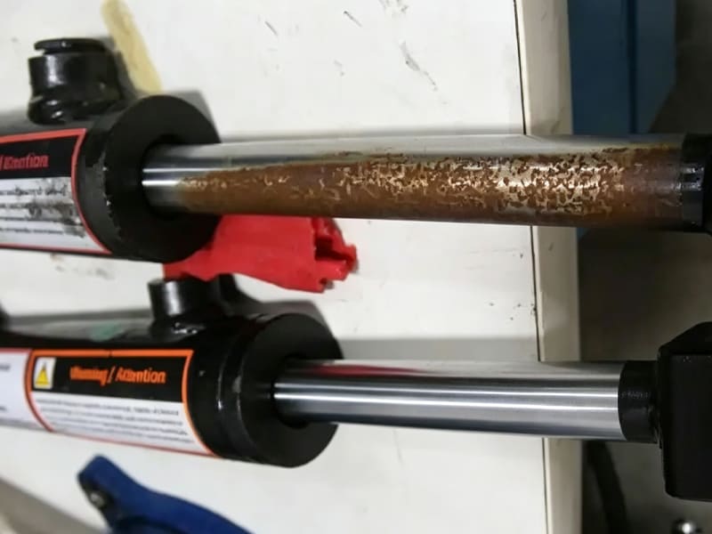 Rusty scratched hydraulic piston rod comparing with new polished rod