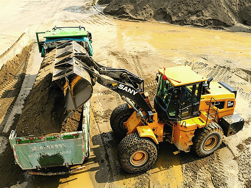 SANY yellow wheel loader loading soil onto dump truck at construction site