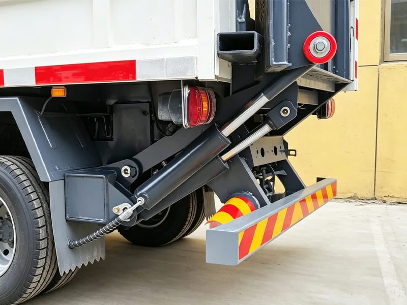 Close-up view of hydraulic cylinders mounted on truck tailgate lifting mechanism