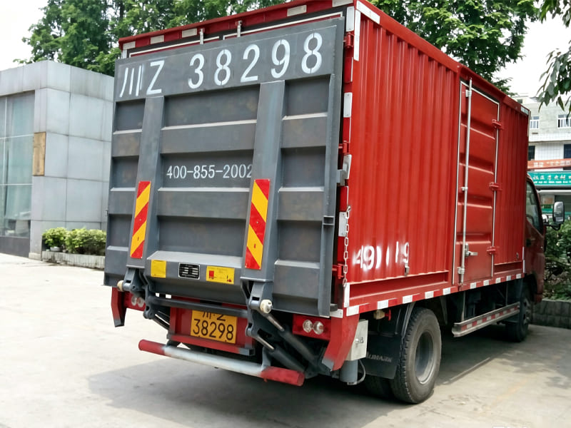 Rear view of red cargo van equipped with hydraulic tailgate lifting equipment
