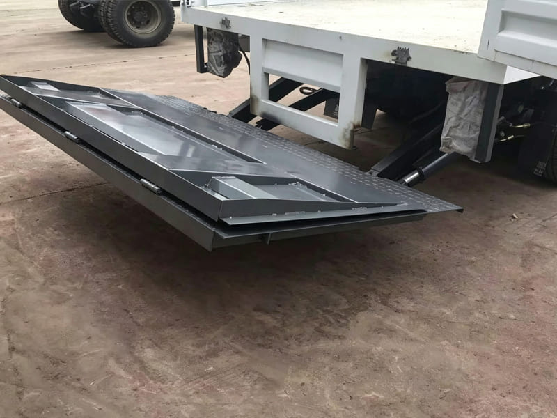 Folded hydraulic tailgate platform mounted on flatbed cargo truck