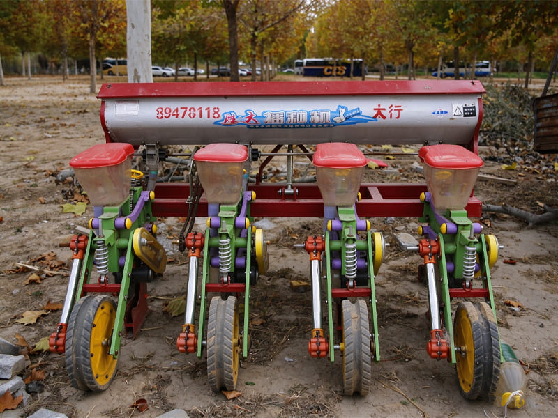 Four row corn seed planter machine, with small hydraulic cylinders on each planting unit, farm seeding equipment on field ground