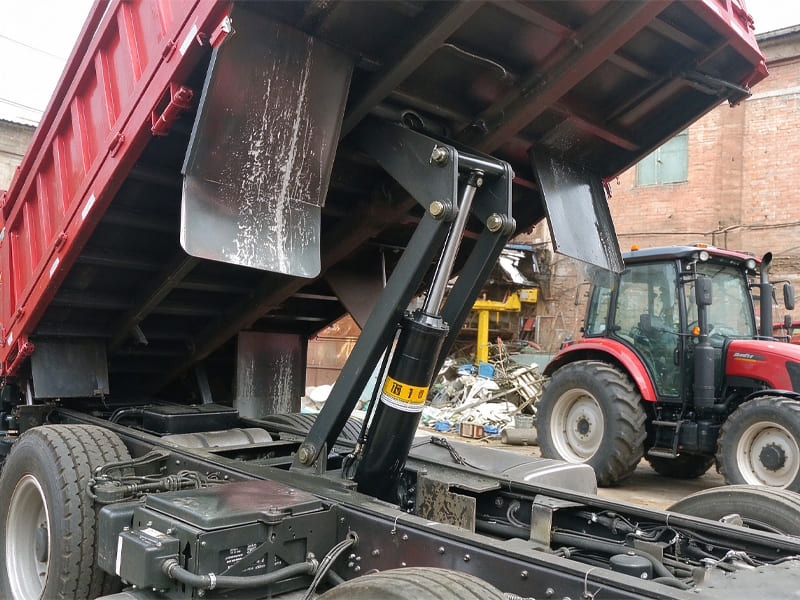 Telescopic hydraulic cylinder mounted under dump truck cargo box, working lifting assembly for tipper lorry.