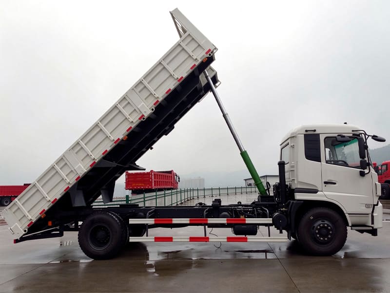 White medium duty hydraulic dump truck, cargo box lifted by single telescopic hydraulic cylinder, outdoor product display