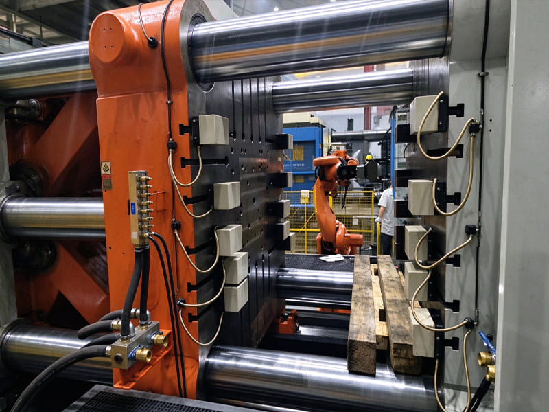 Large die casting machine clamping unit in automated factory workshop with robot arm