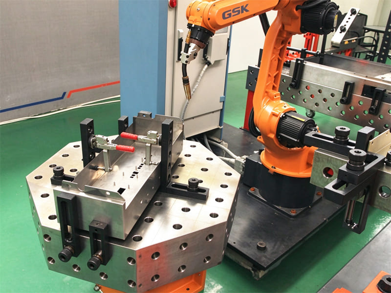 Robotic welding workstation with octagonal modular fixture base and GSK robot