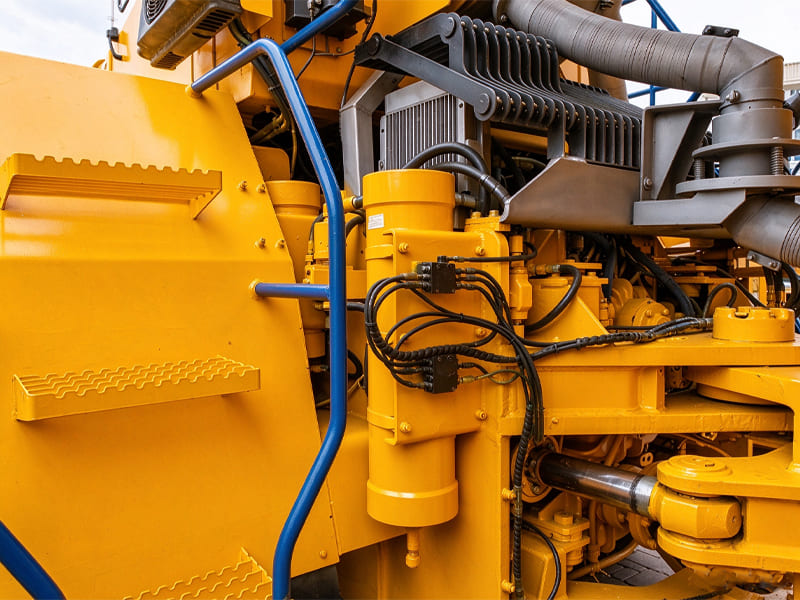 Hydraulic cylinders, hoses and radiator assembly installed on yellow heavy-duty construction machinery chassis