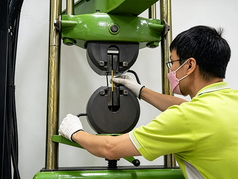 Technician testing material tensile strength of hydraulic cylinder on universal testing machine