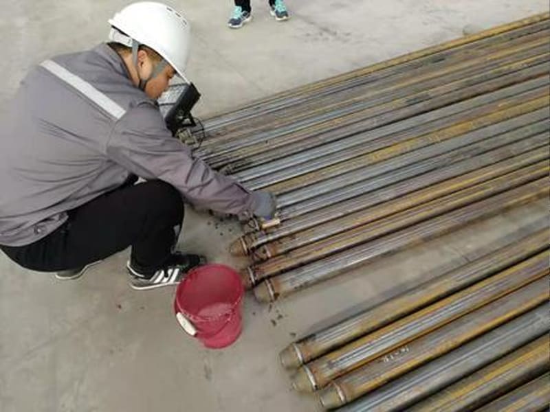 Inspector performing non-destructive testing on steel pipes